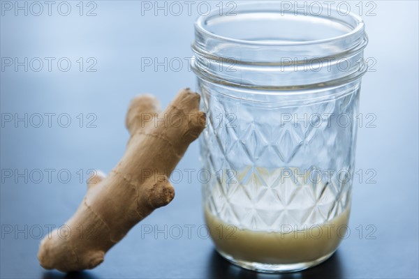 Ginger and homemade juice in drinking glass