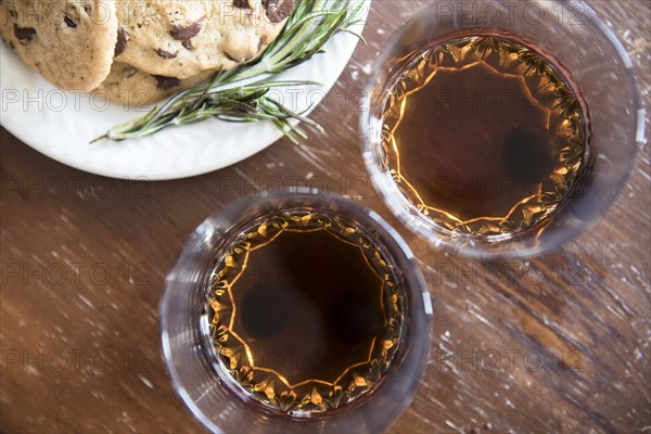 Manhattan cocktail in drinking glass and cookies on plate