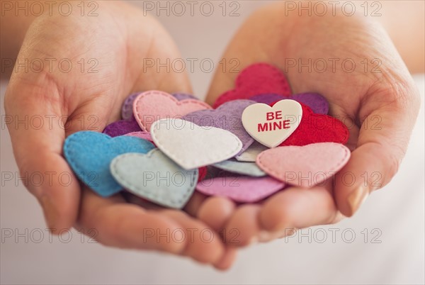 Close-up of woman's hands holding decorations in heart shape