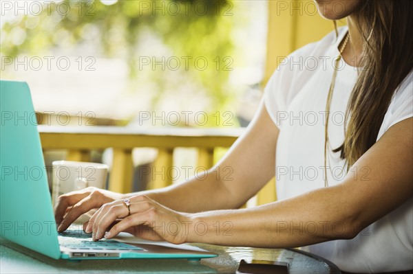 Mid section of young woman using laptop