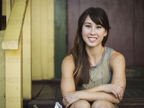 Portrait of young woman sitting on porch