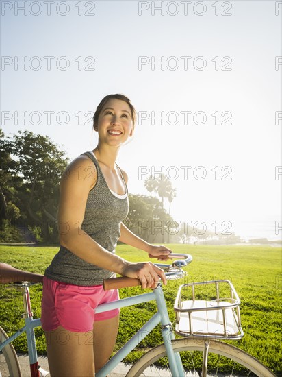 Young woman with bicycle in park