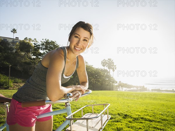 Young woman with bicycle in park