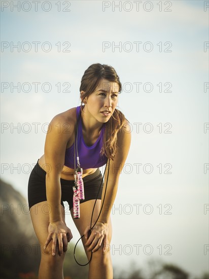 Young woman with jump rope resting
