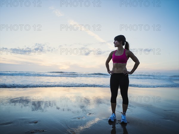 Young woman standing by sea