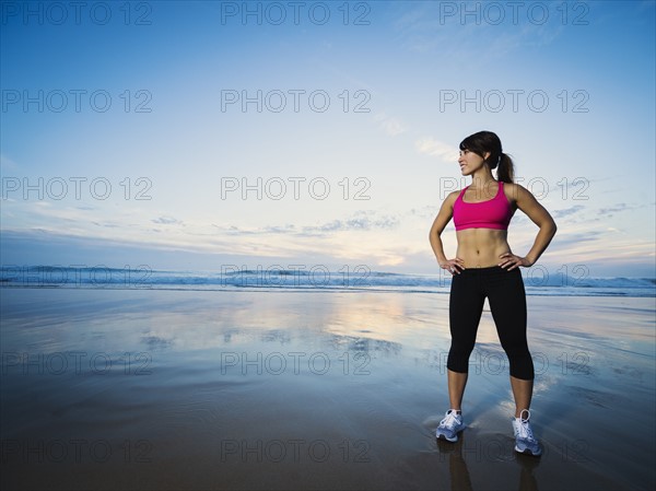 Young woman standing by sea