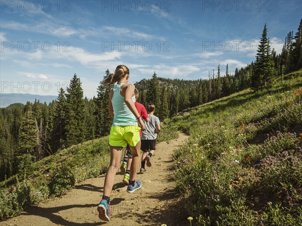 Three children (10-11, 12-13, 14-15) running in mountains