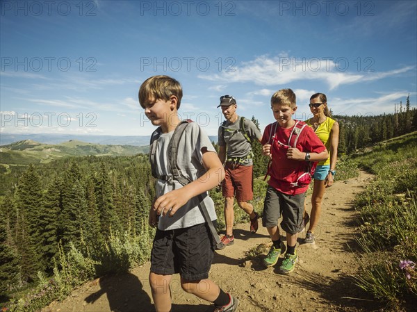 Family with two children (10-11, 12-13) hiking in mountains