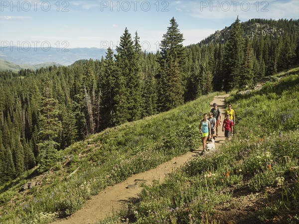 Family with children (10-11, 12-13, 14-15) hiking in mountains