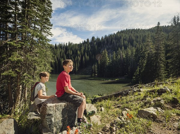 Two boys (10-11, 12-13) resting in forest