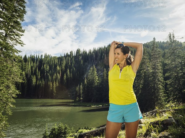 Mature woman stretching in forest