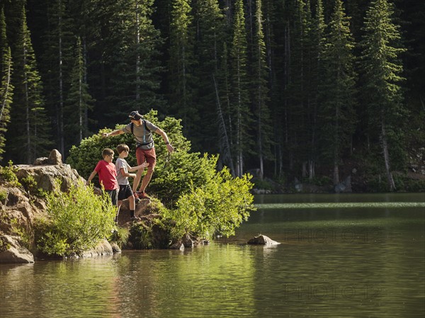 Father with sons (10-11, 12-13) by lake