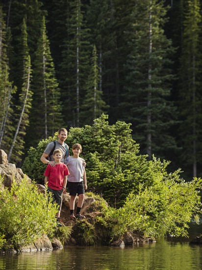 Father with sons (10-11, 12-13) by lake