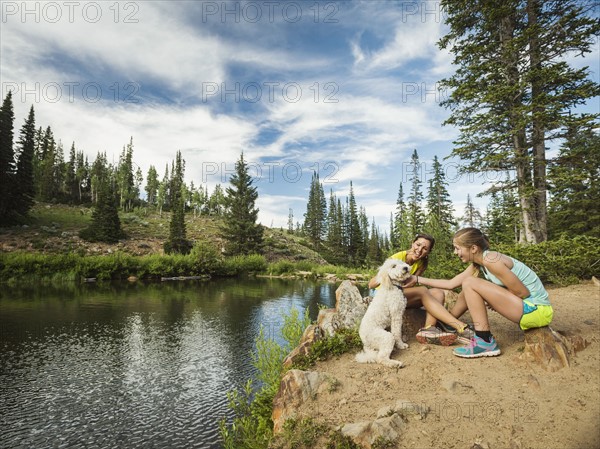 Mother and daughter (14-15) stroking dog