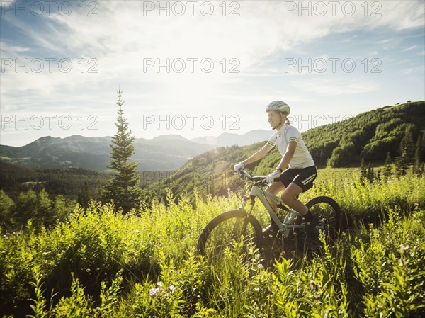 Teenage girl (14-15) during bicycle trip in mountain scenery