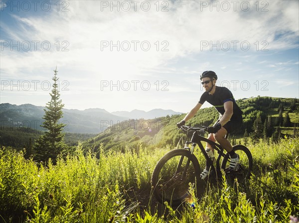 Man during bicycle trip in mountain scenery