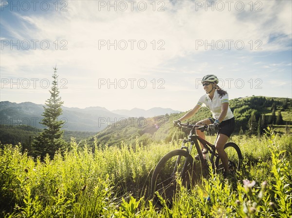 Woman during bicycle trip in mountain scenery