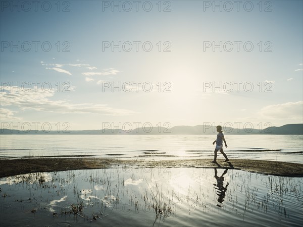 Small girl (4-5) walking on sand on sunny day
