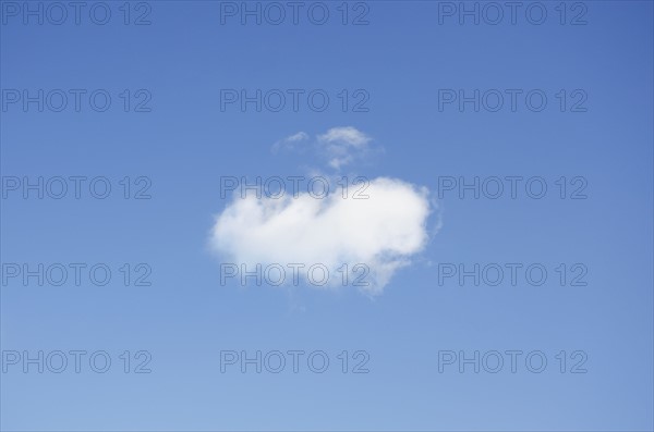 Single cumulus cloud in blue sky
