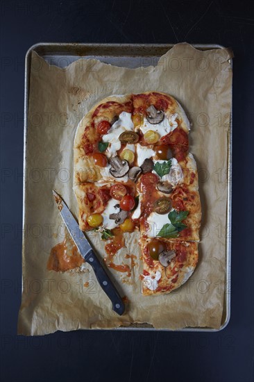 Homemade pizza on baking sheet