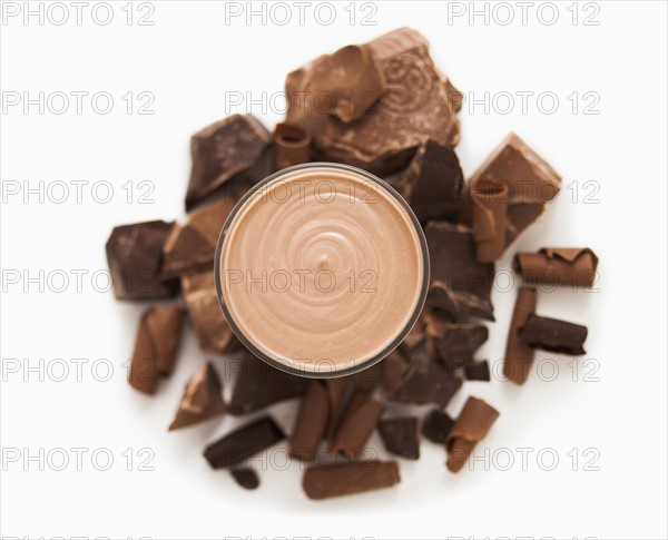 Chocolate smoothie in glass and lots of pieces of chocolate