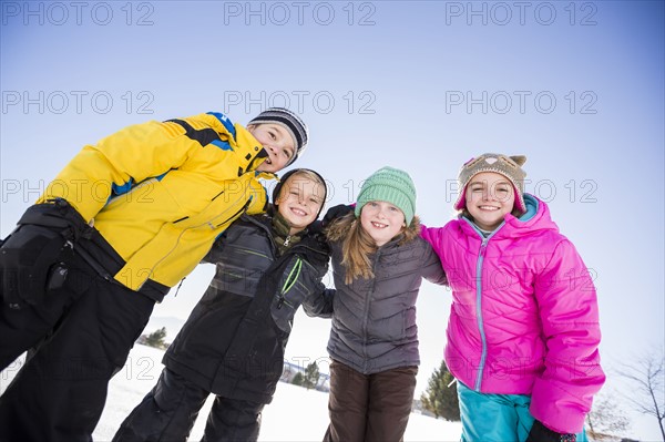 Children (8-9, 10-11 ) standing in snow