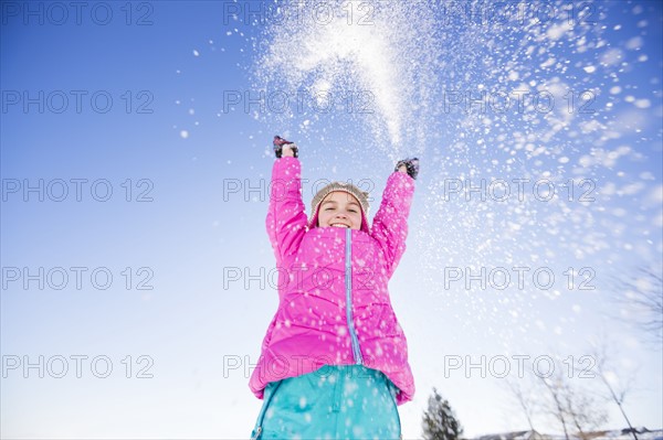 Girl (10-11) playing with snow