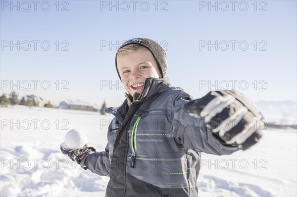Boy (8-9) throwing snowball