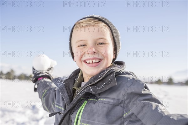 Portrait of boy (8-9) throwing snowball