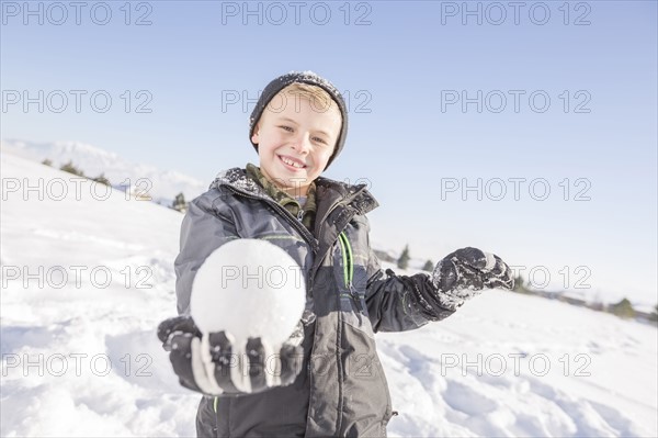 Portrait of boy (8-9) holding snowball