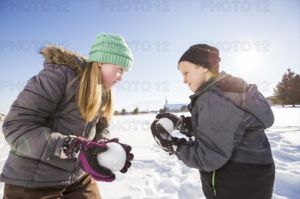 Children (8-9, 10-11) playing with snowballs