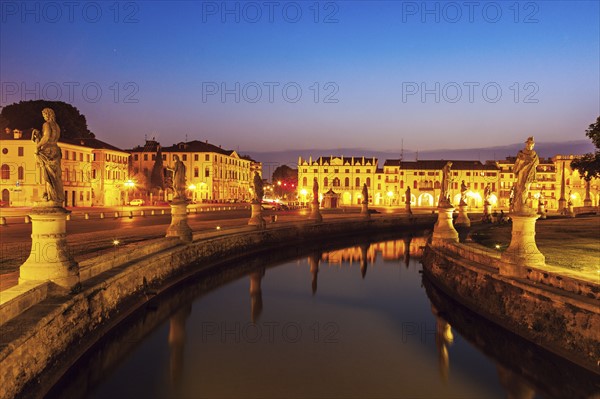 Illuminated Prato della Valle with statues at dusk