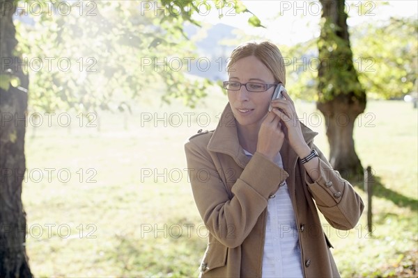 Woman in beige coat talking on phone