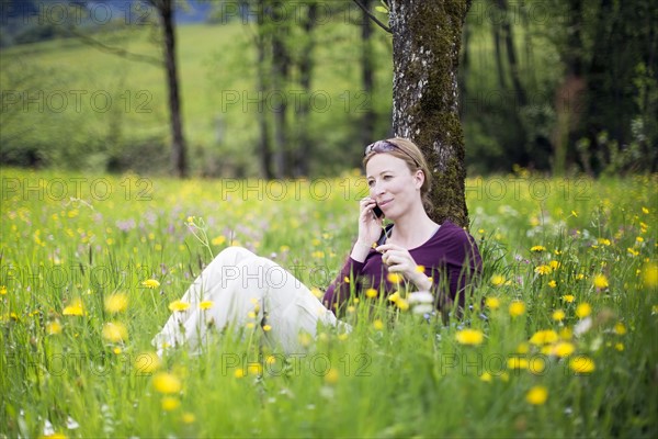 Woman talking on phone in meadow