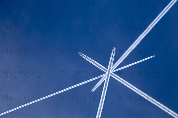 Crossed vapor trails of airplanes in blue sky