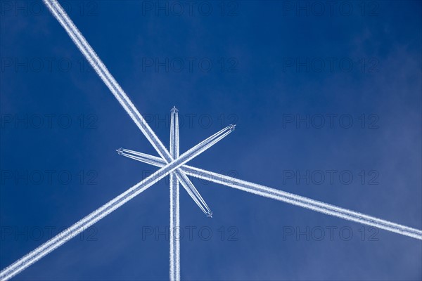 Crossed vapor trails of airplanes in blue sky