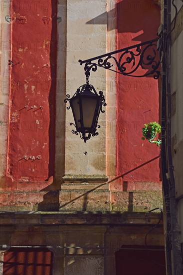 Ornate street light against red wall