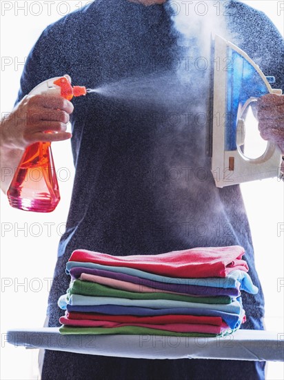 Man spraying iron with spray bottle