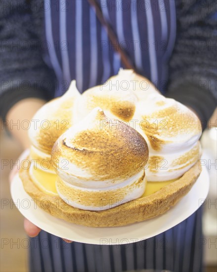 Mature woman holding pie with meringue