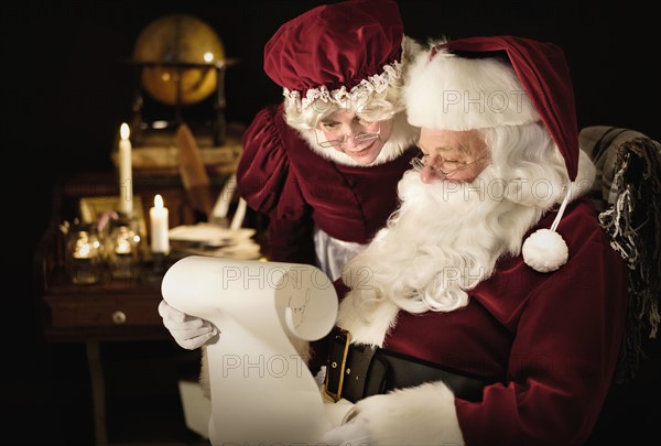 Santa and Mrs. Claus reading child's letter.