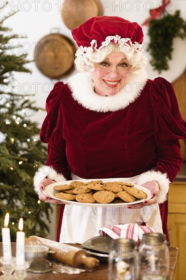 Portrait of Mrs. Claus holding fresh gingerbread cookies.