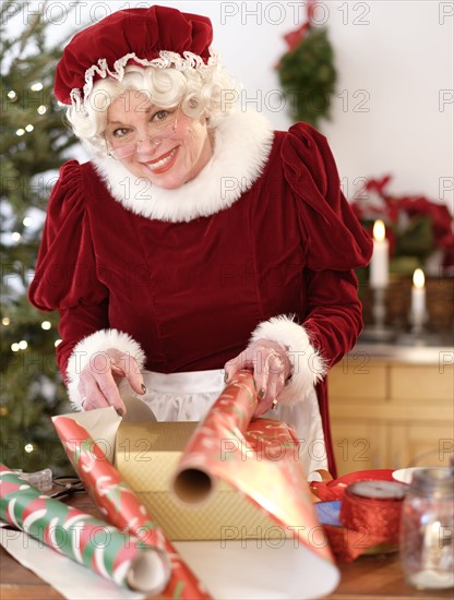 Mrs. Claus wrapping Christmas gifts.