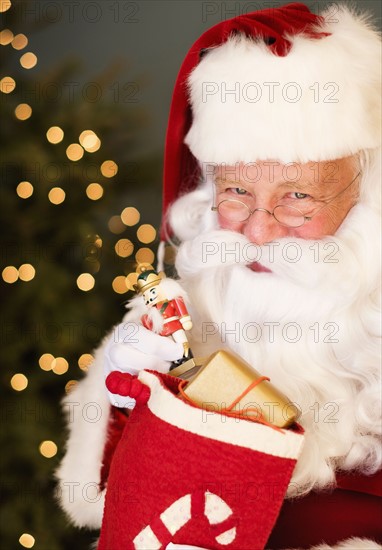 Portrait of Santa Claus holding nutcracker toy.