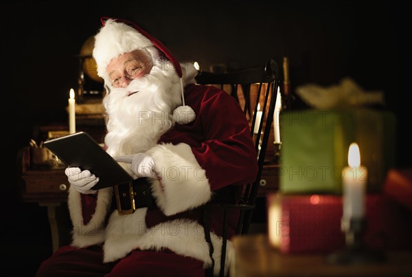 Santa Claus using digital tablet.