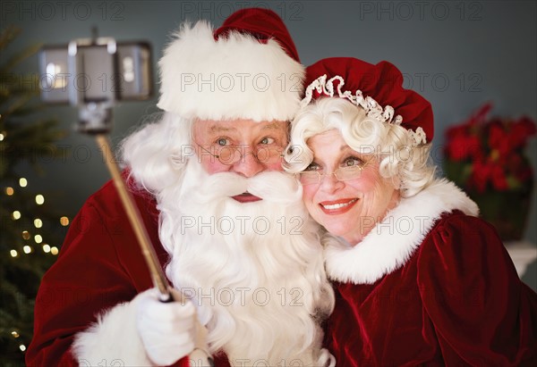 Santa and Mrs. Santa taking selfie with monopod.