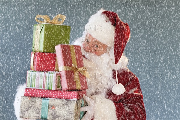 Portrait of Santa Claus carrying Christmas presents.