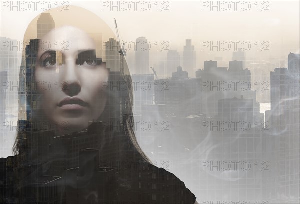 Double exposure of young woman's face over cityscape. USA, New York, New York City.