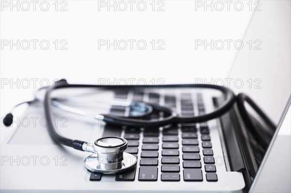 Stethoscope lying on laptop.