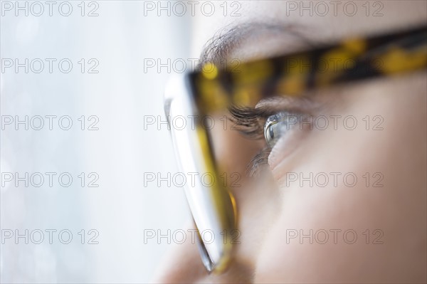 Close up of young woman with blue eyes wearing glasses.
