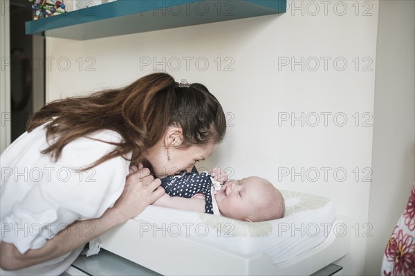 Mother kissing baby daughter (2-5 months).